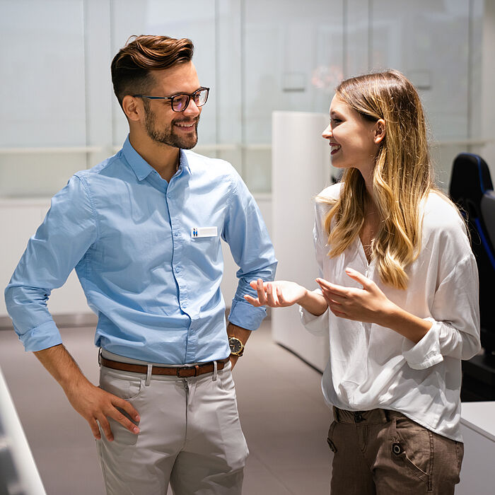 Photo shows two people in business attire having a conversation