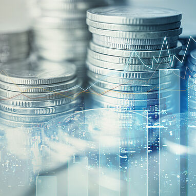 Image shows stacks of coins in the background and a trend chart in the foreground