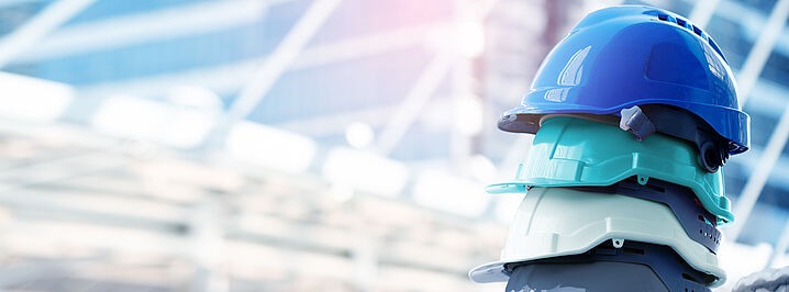 Photo shows several protective helmets stacked on top of each other.