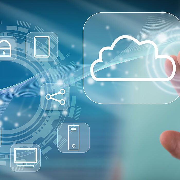 Auf dem Bild tippt eine Person auf ein Cloud-Symbol, daneben sind verschiedene Icons zum Thema IT kreisförmig angeordnet