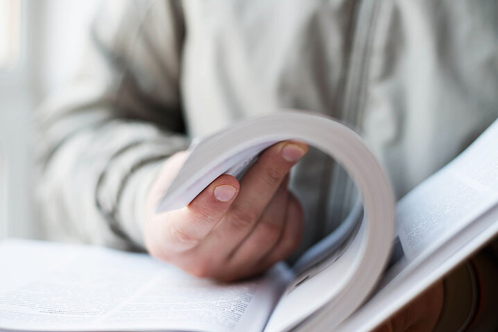 Foto einer Person, die in einem Buch blättert