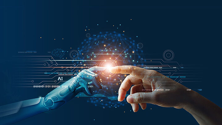 Image shows a robotic hand and a human hand touching each other