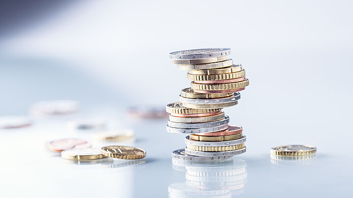 Image shows a stack of coins with other coins scattered around it.
